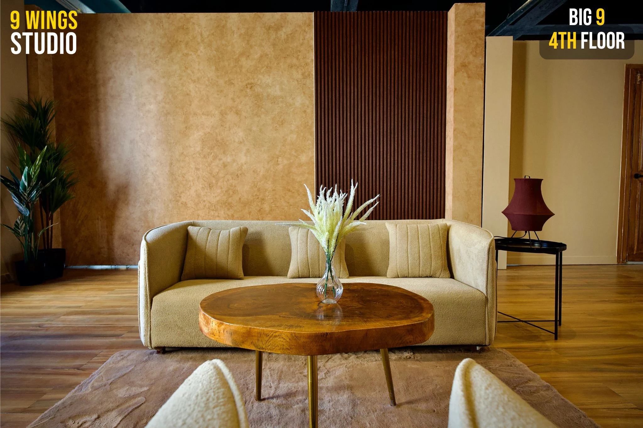 Podcast studio backdrop with a cream sofa and wooden coffee table at 9 Wings Studio, Andheri West
