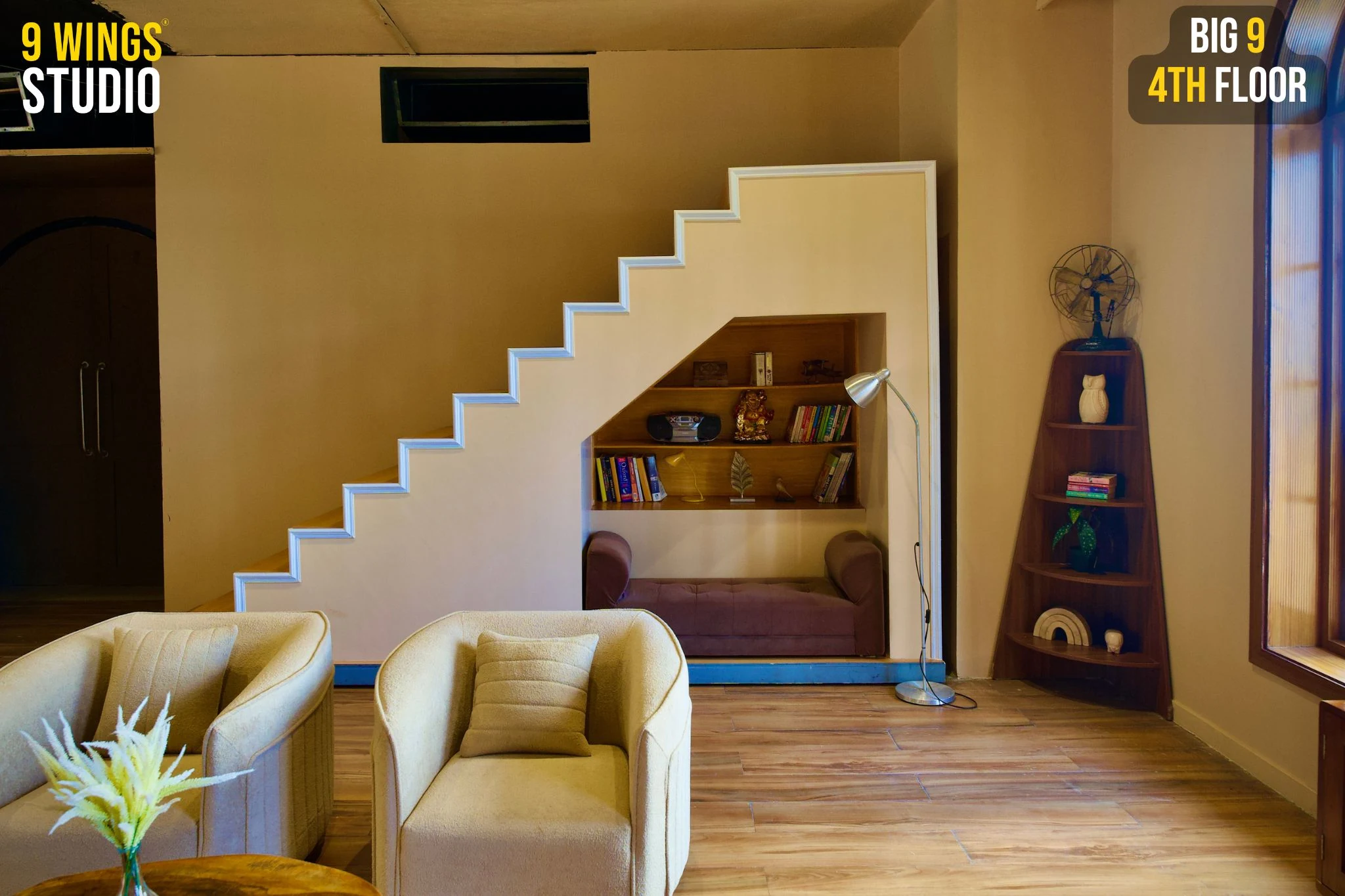 Podcast studio in Andheri West with a staircase bookshelf nook and cream armchairs at Big 9, 4th Floor
